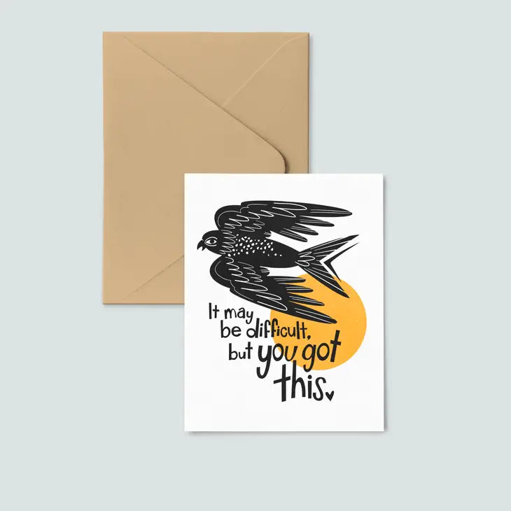 envelope underneath white card, print of black bird and text reading "it may be difficult, but you got this"