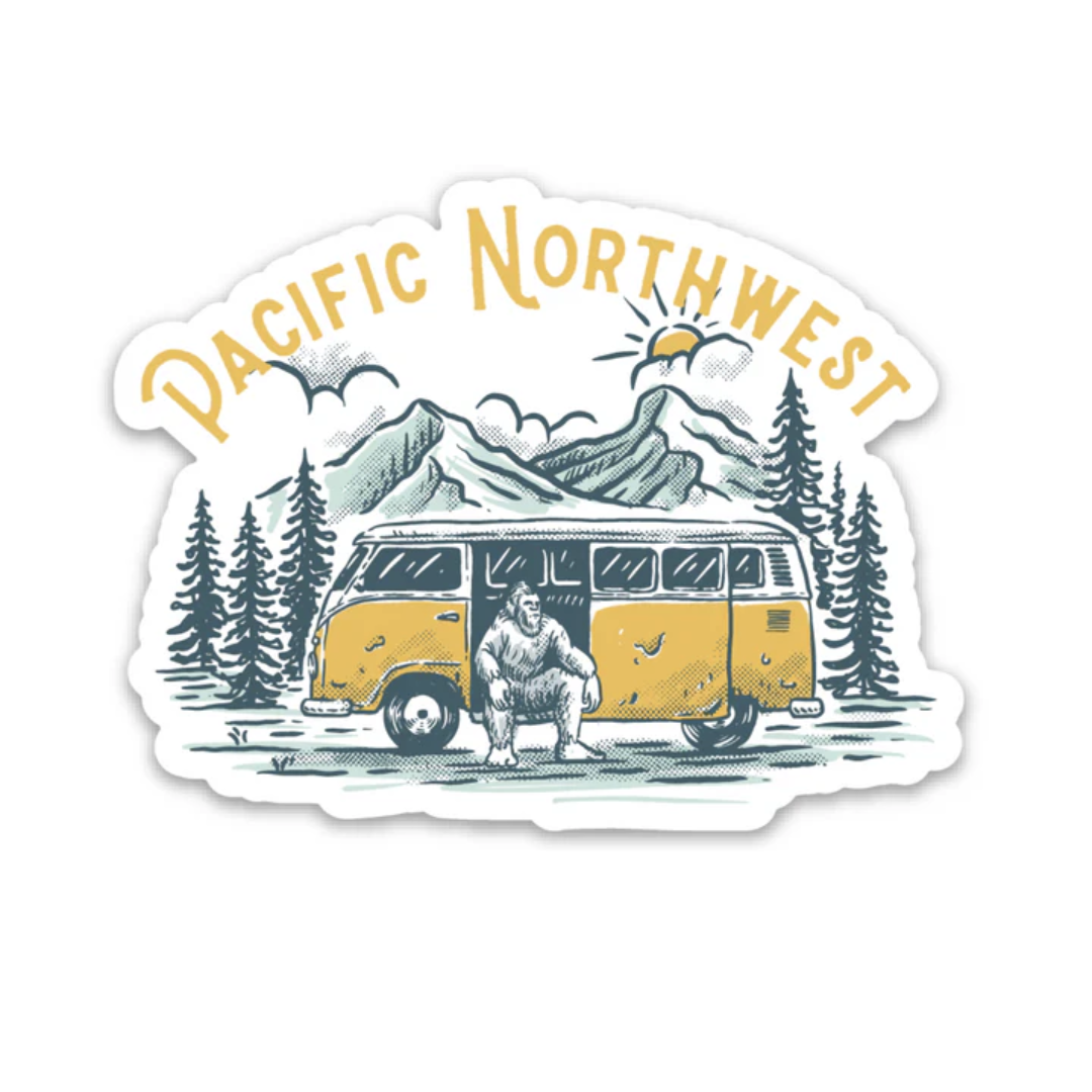 Sticker says "Pacific Northwest" and features Sasquatch sitting in a yellow VW Bus in the outdoors with evergreen trees, mountains, and sky