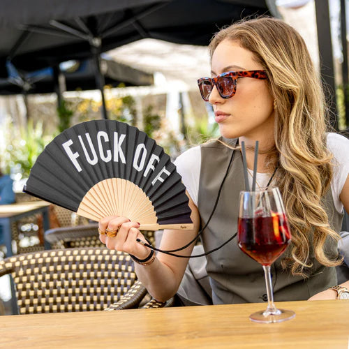 Model holds the fan and enjoys a drink
