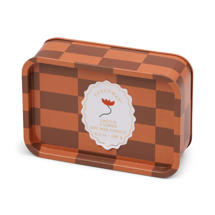 Orange and brown checkered tin with white label. Label has an orange flower and reads "Paddywax Cactus Flower Soy Wax Candle 6.5 oz - 184 g"