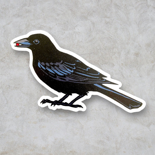 Black crow sticker with a white boarder. Crow holds a little red seed or gem in their beak, a sort of nifty gifty for some lucky friend. 