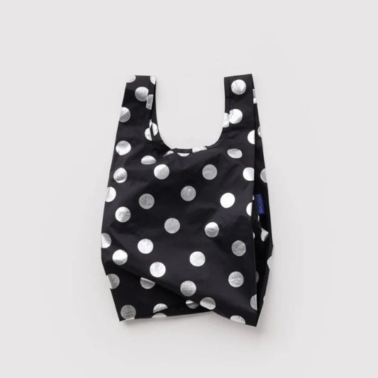 A reusable black plastic shopping bag with a silver polka dot pattern, photographed against a neutral light gray background.