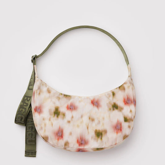 Floral patterned handbag with a green strap on a light gray background