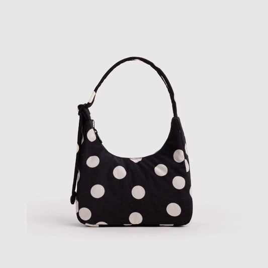 A black hobo shoulder bag with large white polka dots, featuring a single top handle and a side zipper, shown against a plain light gray background.
