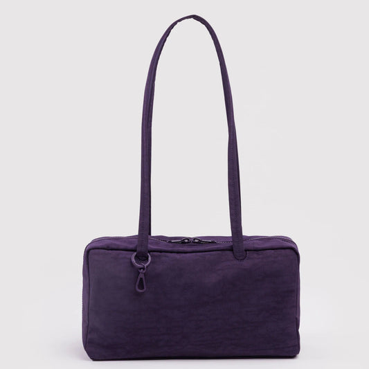 Purple handbag with a strap on a light purple background