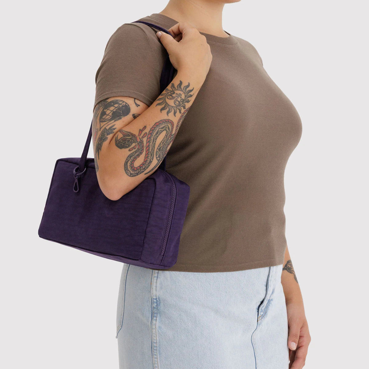 Person holding a purple bag against a white background
