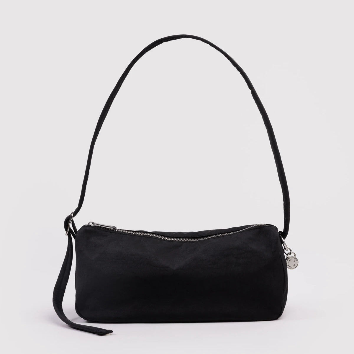 Black handbag with a strap on a light gray background