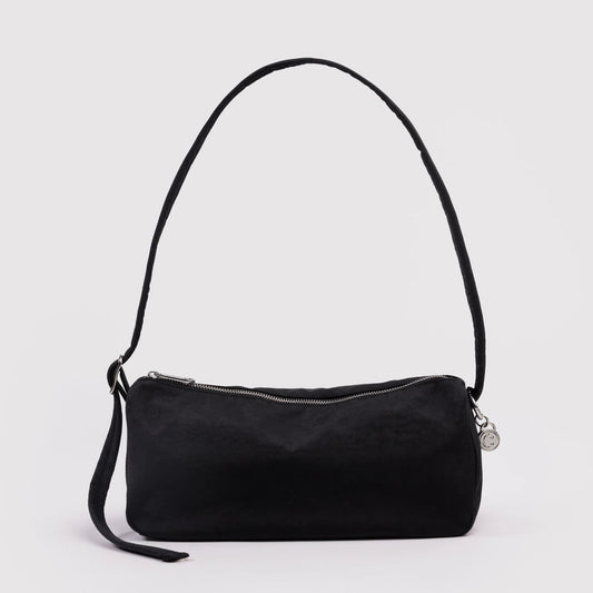 Black handbag with a strap on a light gray background