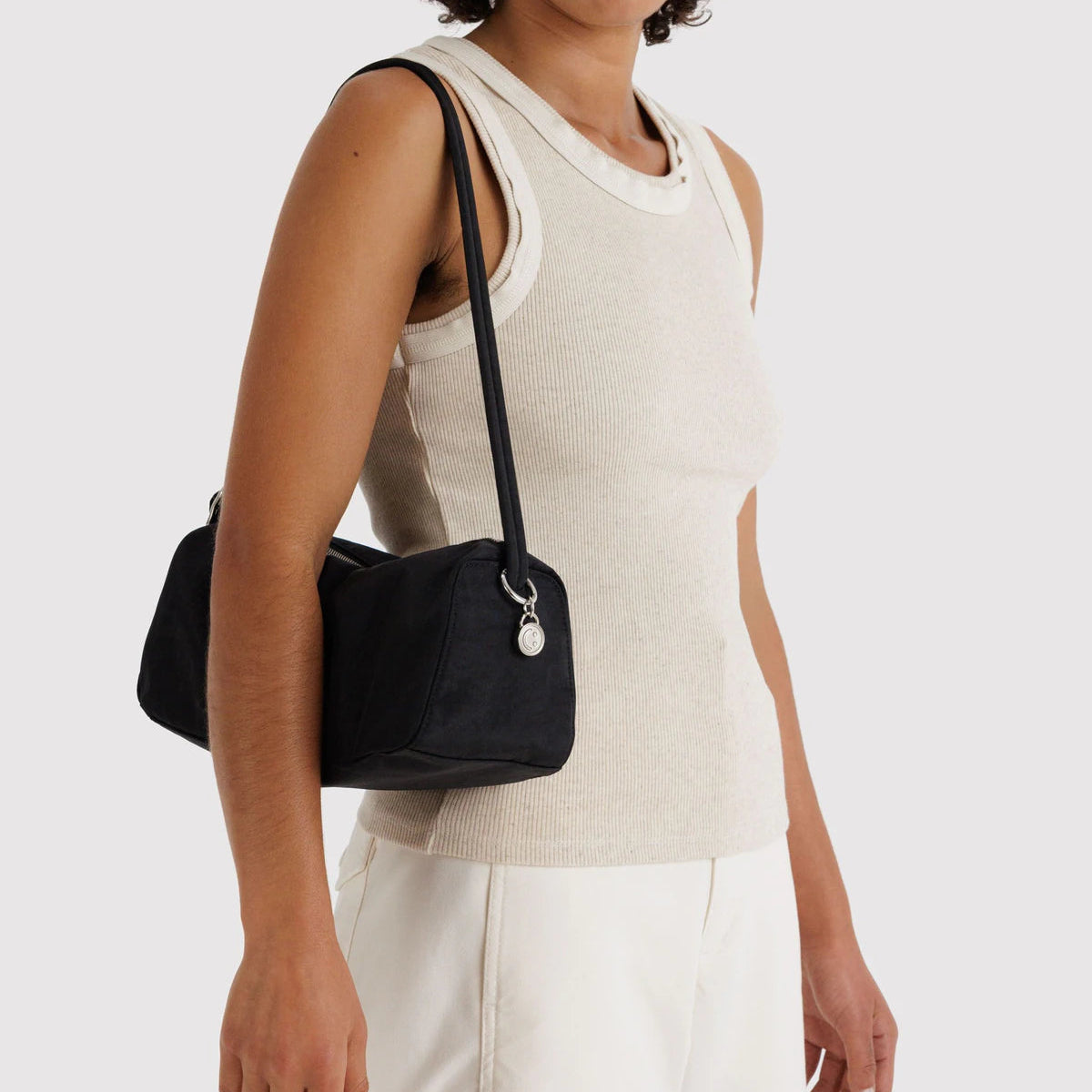 Woman wearing a black shoulder bag on a white background