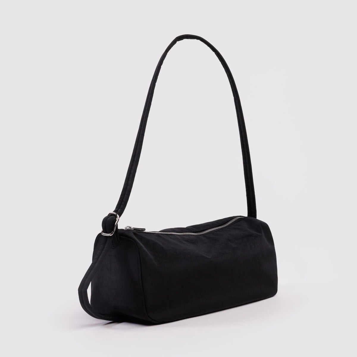 Black handbag with a strap on a light gray background