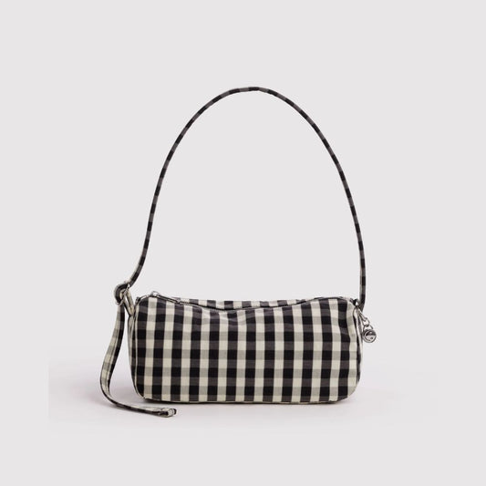 A small black and white gingham check shoulder bag with a thin matching shoulder strap and a wristlet strap, shown on a light gray background.