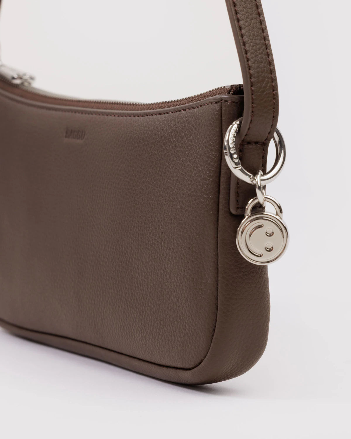 Brown handbag with a keychain on a white background