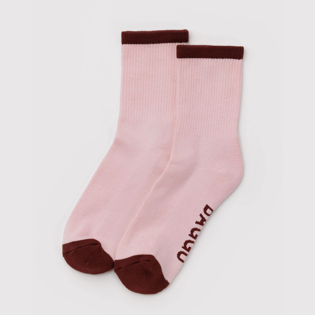 Pink socks with brown accents on a light gray background