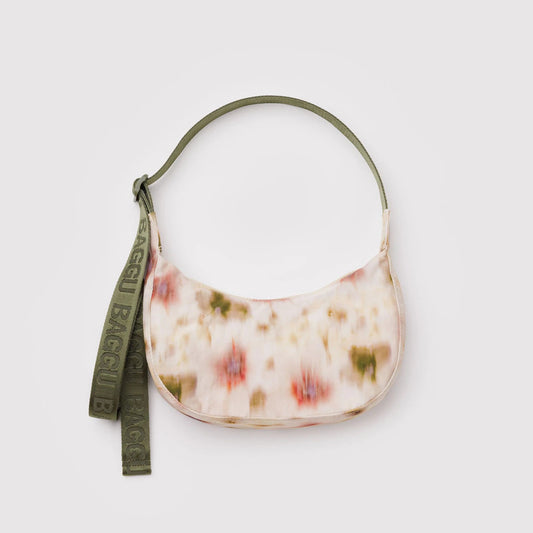 Floral patterned handbag with a green strap on a light gray background