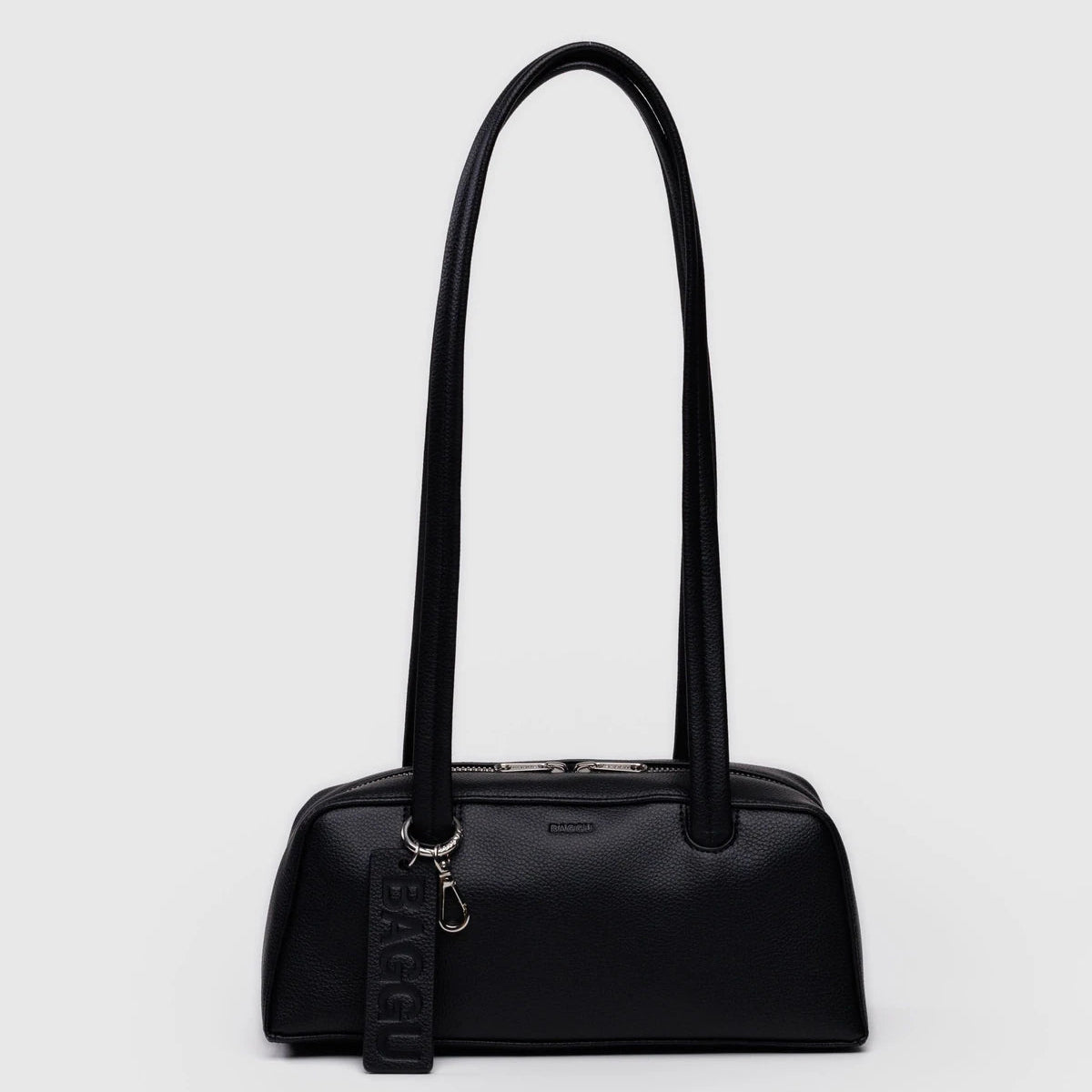 Black handbag with a strap on a light gray background