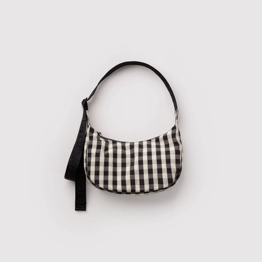A small crescent-shaped shoulder bag with a black and off-white gingham check pattern, featuring a black strap, shown against a plain light gray background.