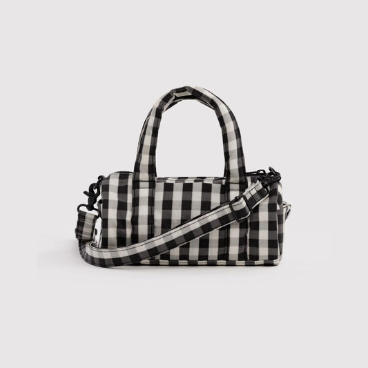 A black and white buffalo check patterned handbag with dual top handles and an adjustable shoulder strap, shown against a light gray background.