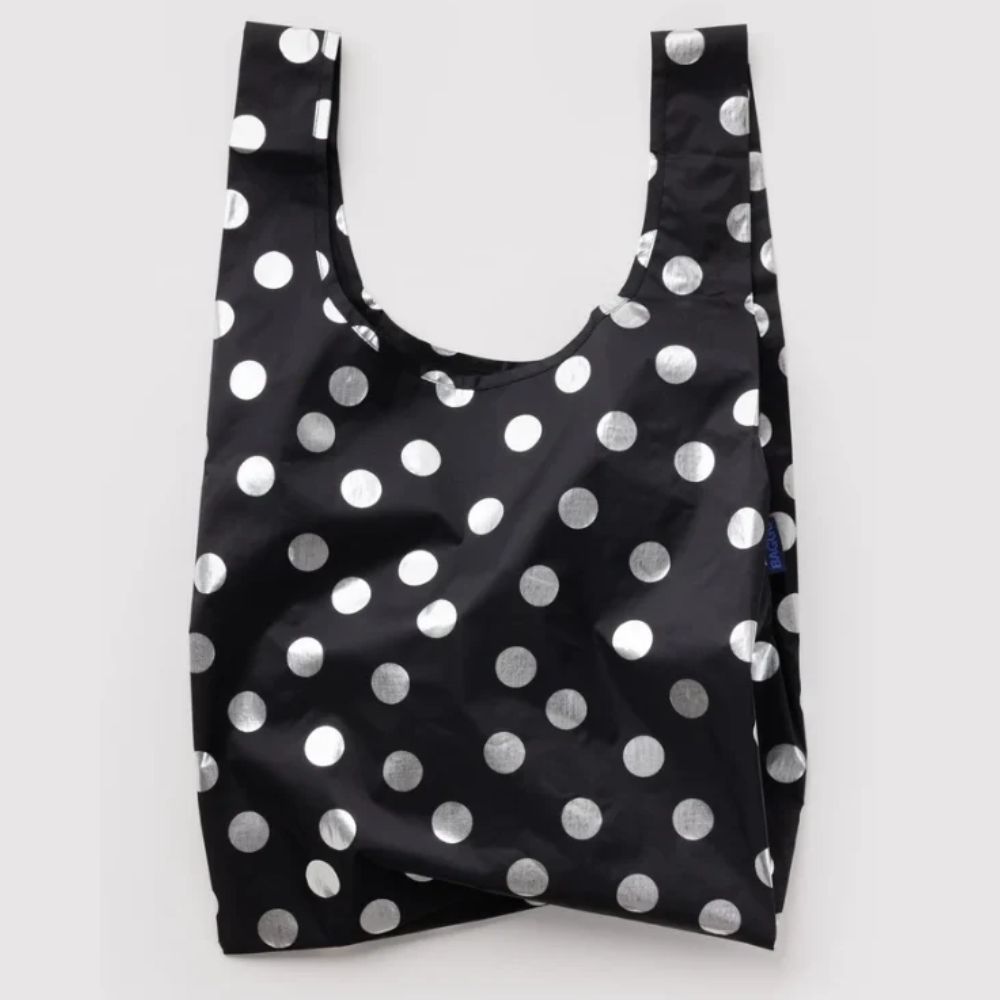 A reusable black plastic shopping bag with a shiny silver polka dot pattern, shown against a plain light gray background.