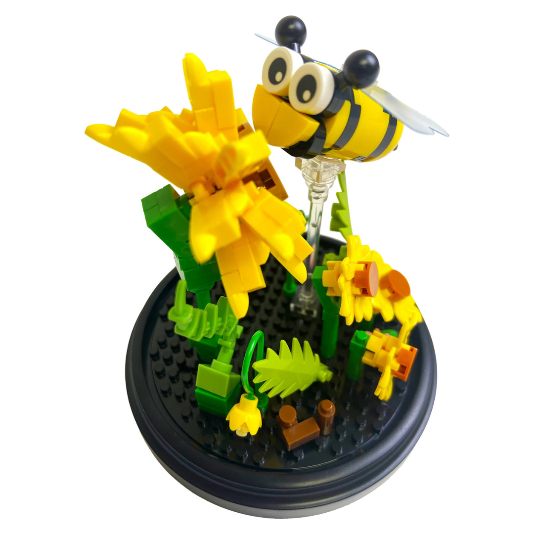 Toy blcok bee and flowers on a black base with a white background