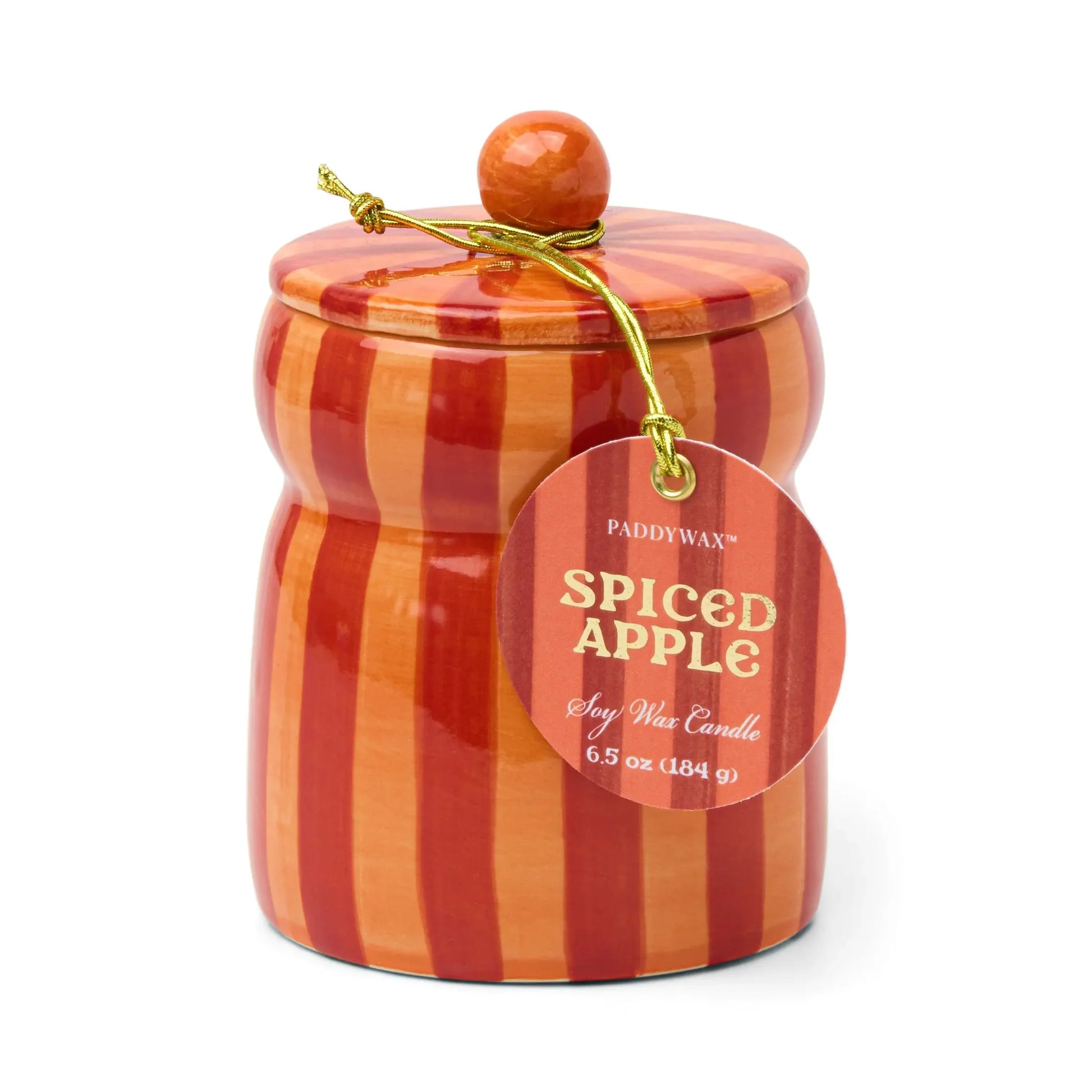 Candle in an orange and red striped ceramic vessel. Candle has a lid with an orange knob. Tag reads "Paddywax Spiced Apple Soy Wax Candle"