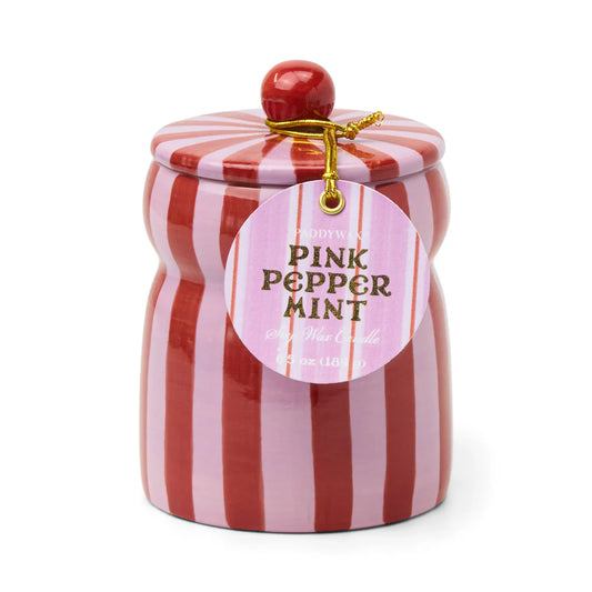 Candle in red and pink striped ceramic vessel with lid. Lid has a red knob. Label reads "Paddywax Pink Peppermint Soy Wax Candle"