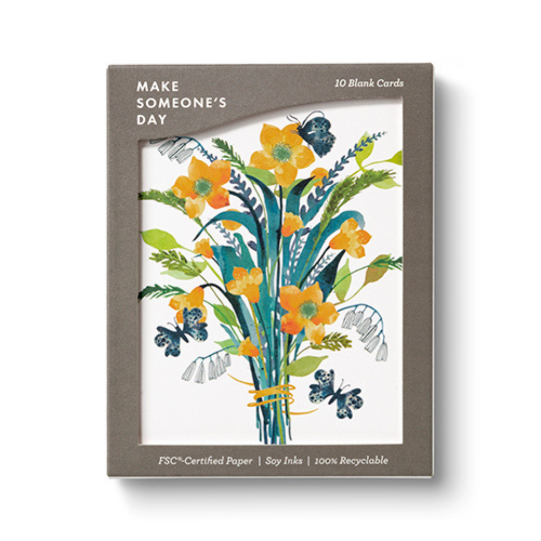 Brown box with a large open window displaying the cards.  The cards are white and feature a bouquet of orange and yellow flowers with blue and green foliage and butterflies floating about. The box says "Make Someone's Day" in the upper right hand corner and "10 Blank Cards" in the upper left. Along the bottom it says "FSC Certified Paper|Soy Ink|100% Recyclable"
