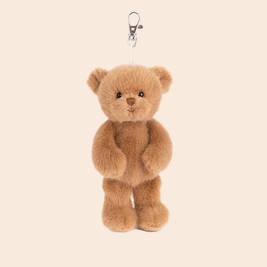 Brown teddy bear keychain on a beige background