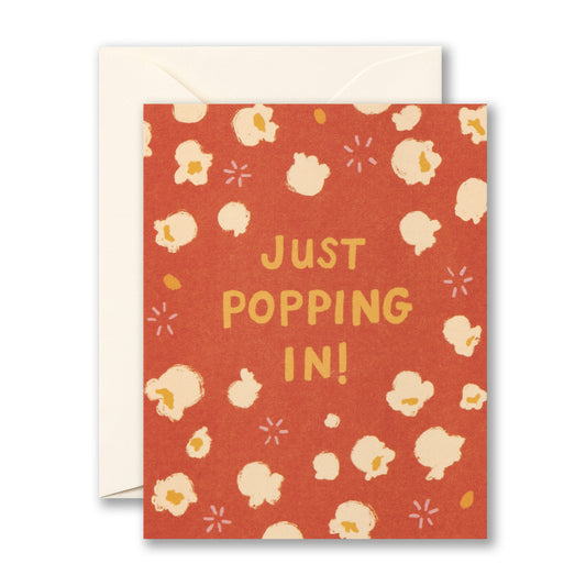 Greeting card with popcorn pattern and 'Just Popping In!' text on a red background