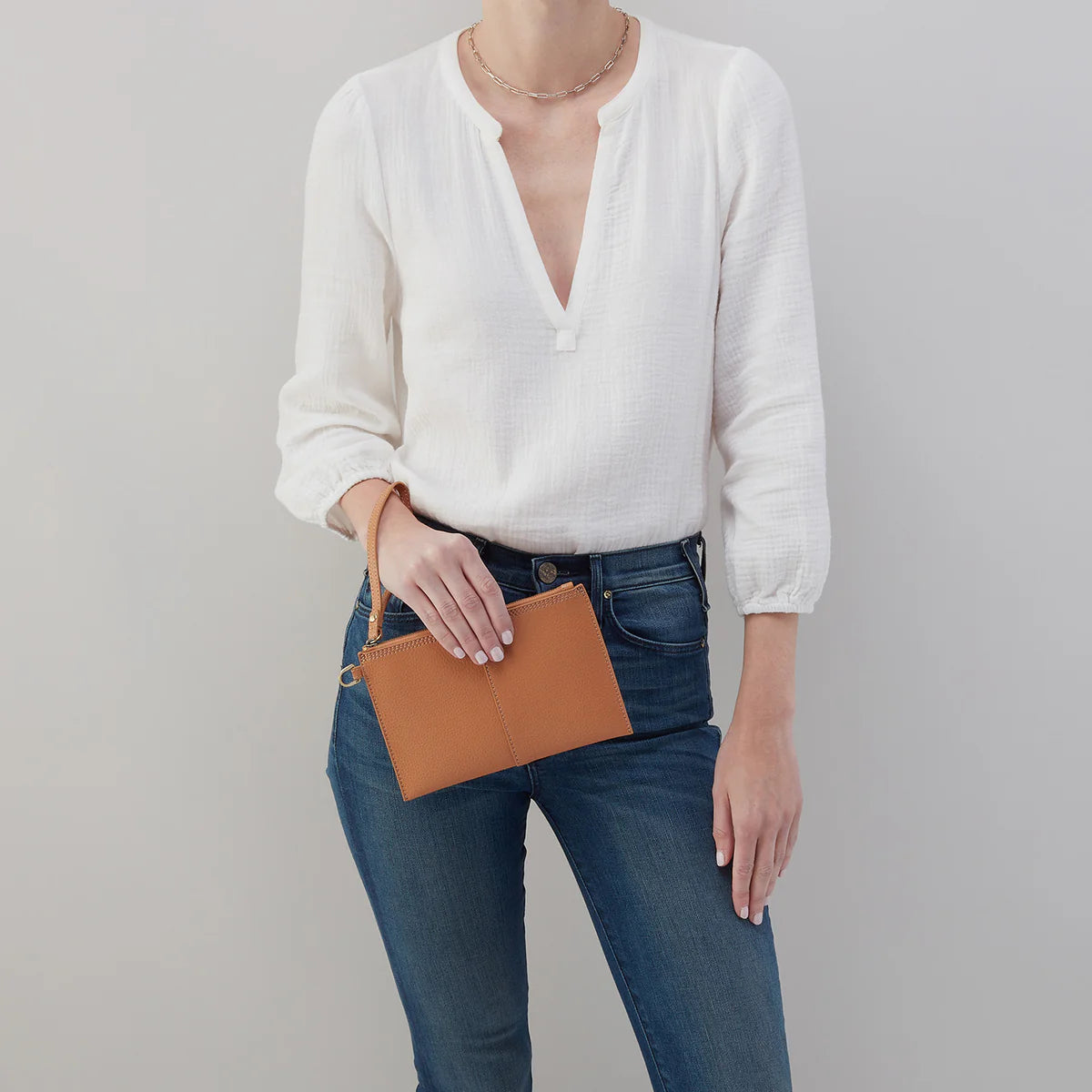 Model holding the Vida small pouch for scale