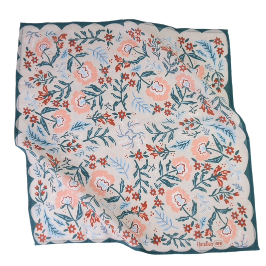 A square scarf with a scalloped edge, featuring a hand-drawn style botanical pattern in coral, teal, and light blue on a cream background, with a dark teal border.