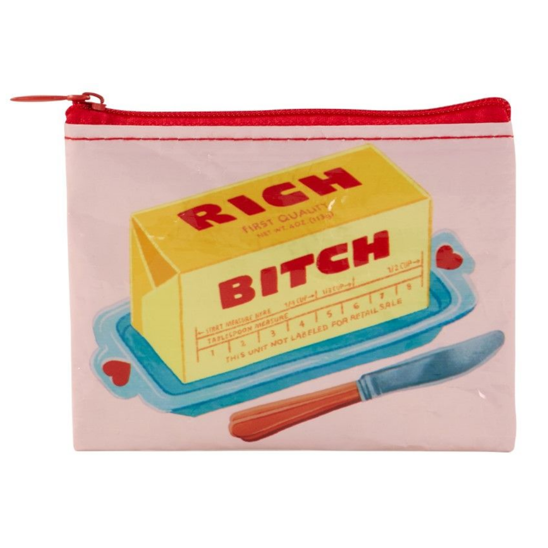 Coin purse with a pink background. In the foreground is a stick of butter on a tray with red hearts and a butter knife. The stick of butter reads "Rich B*tch"