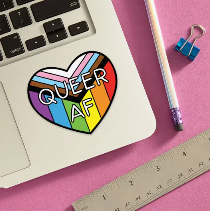 Heart shaped Queer AF sticker placed on a laptop
