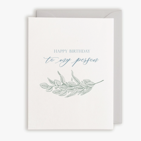 White card with grey envelope. Text in blue "Happy Birthday to my person" with branch of leaves below
