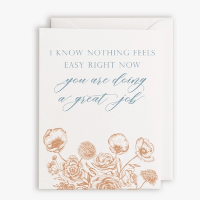 White card with orange illustrated flowers on bottom and blue text saying 