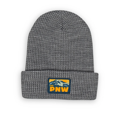 Grey beanie with patch on the front featuring a mountain and the text The PNW