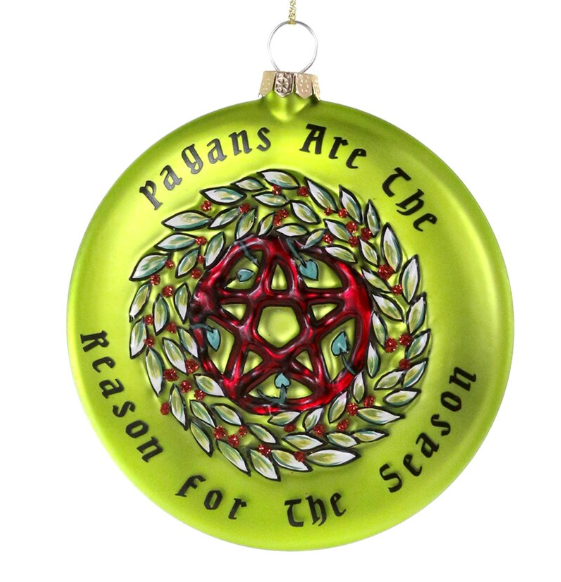Green glass ornament with pentacle design in the middle of a wreath with text that reads "Pagans are the reason for the season"