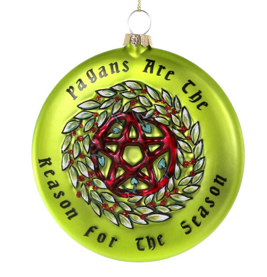 Green glass ornament with pentacle design in the middle of a wreath with text that reads "Pagans are the reason for the season"