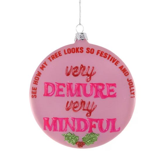 Pink Christmas ornament says "see how my tree looks so festive and jolly? Very Demure, Very Mindful." with holly decorations 