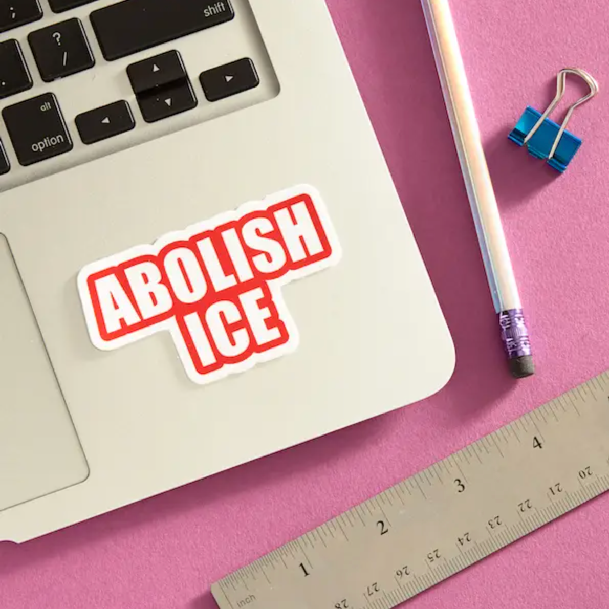 Sticker that says "Abolish ICE" in red placed on the keyboard of a laptop.