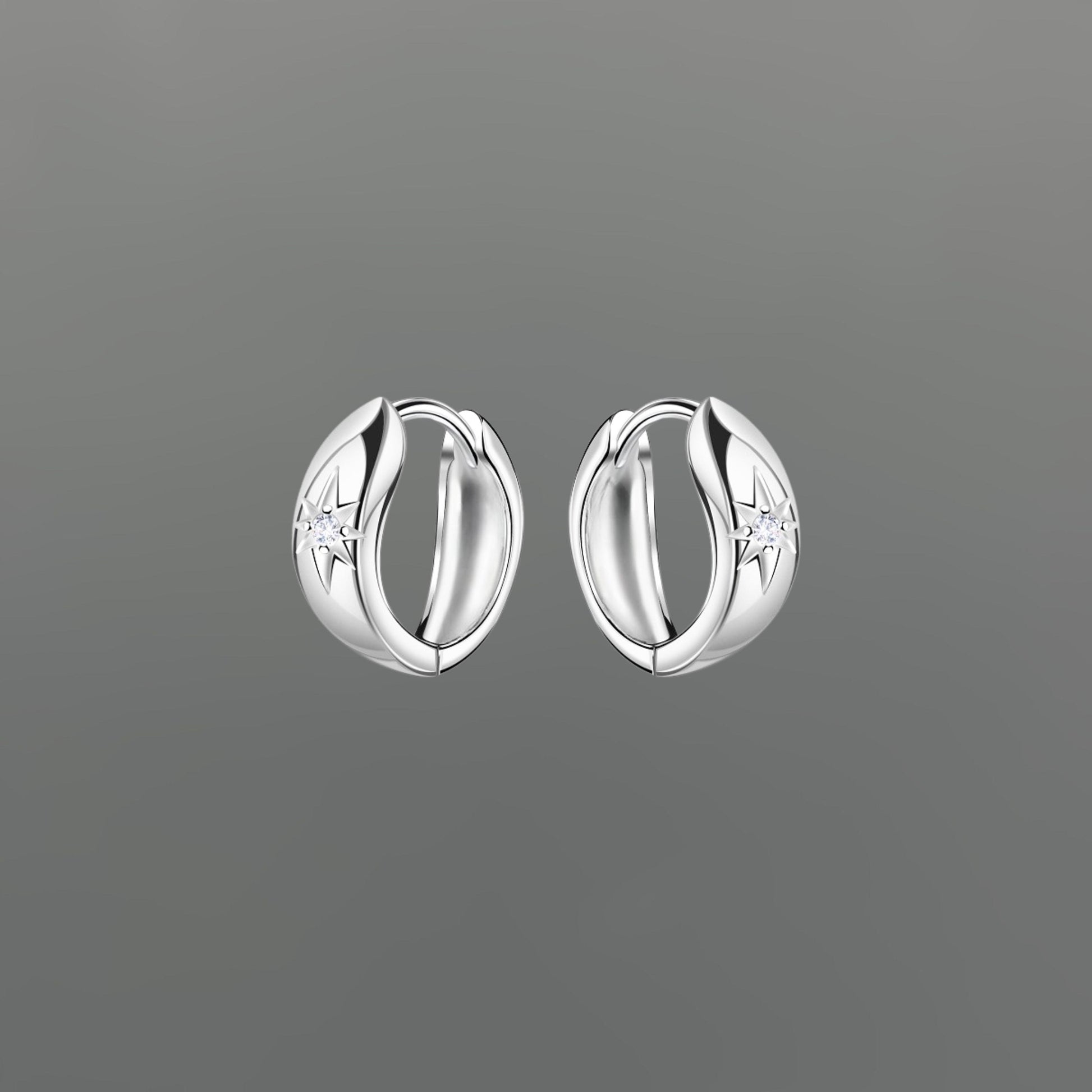 Pair of silver hoop earrings with star sparkle on a gray background
