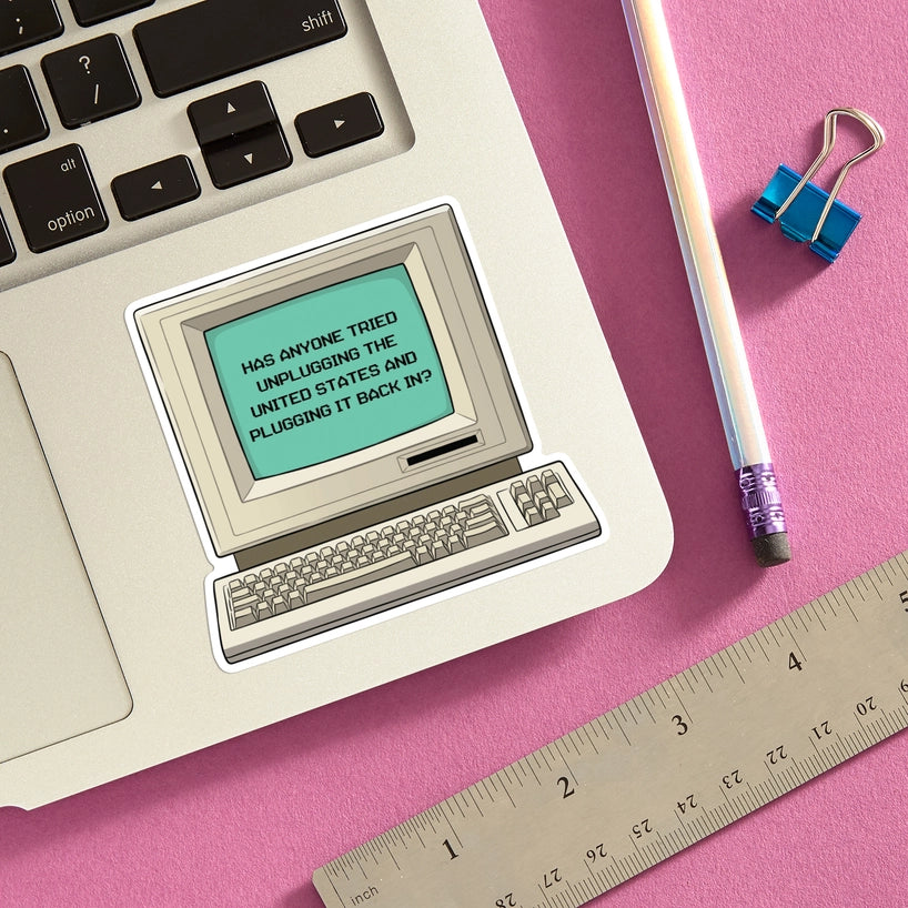 Sticker of a vintage computer with text on a pink surface with a ruler and pencil.