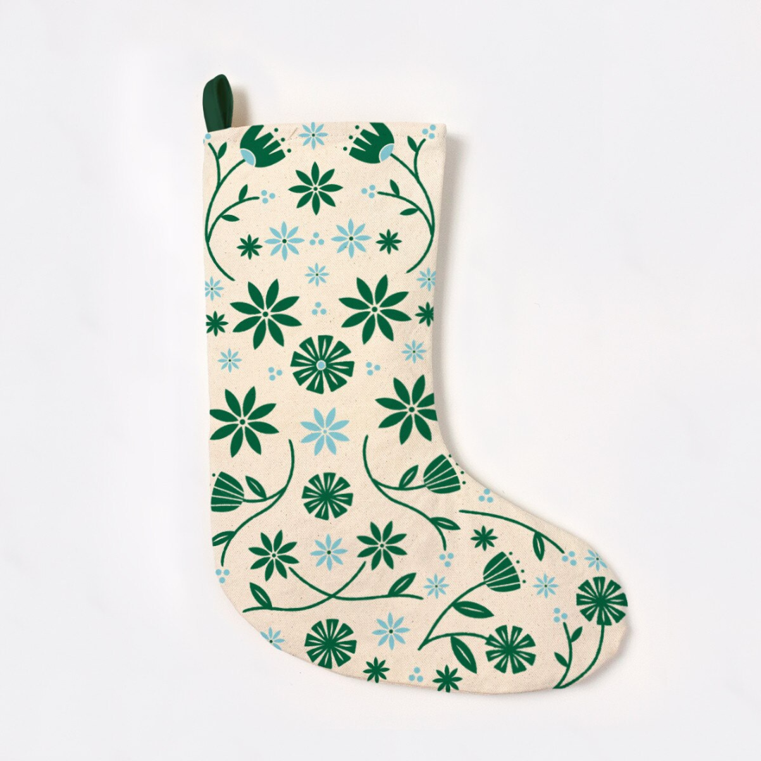 Creamy white stocking patterned with green and blue flowers featuring a green hook at the top to hang.