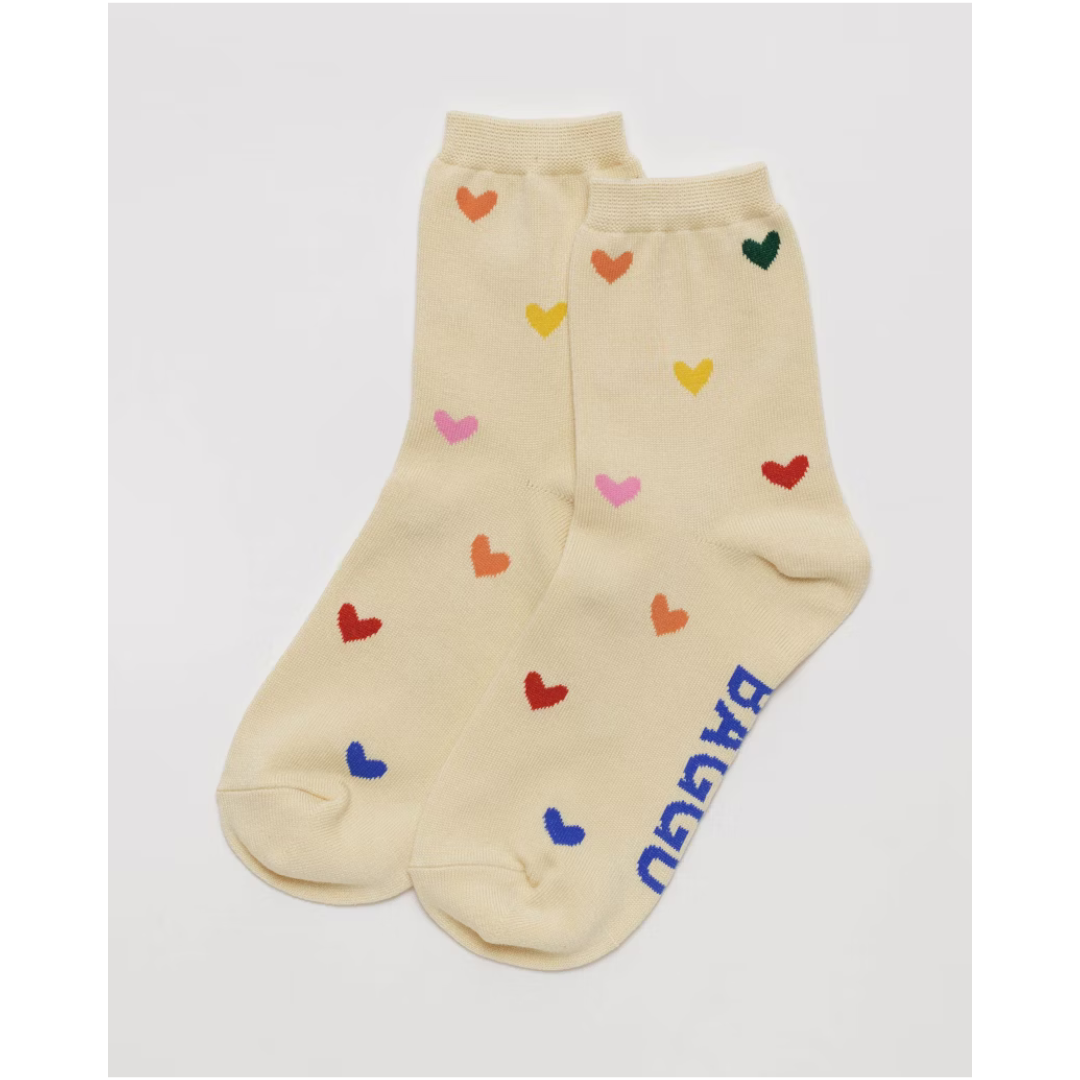 Off white crew sock featuring hearts all over in all colors of the rainbow and the word "BAGGU" in blue font on the bottom,