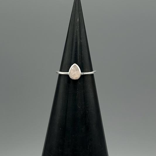 Silver banded ring featuring a teardrop shaped stone of rose quartz.