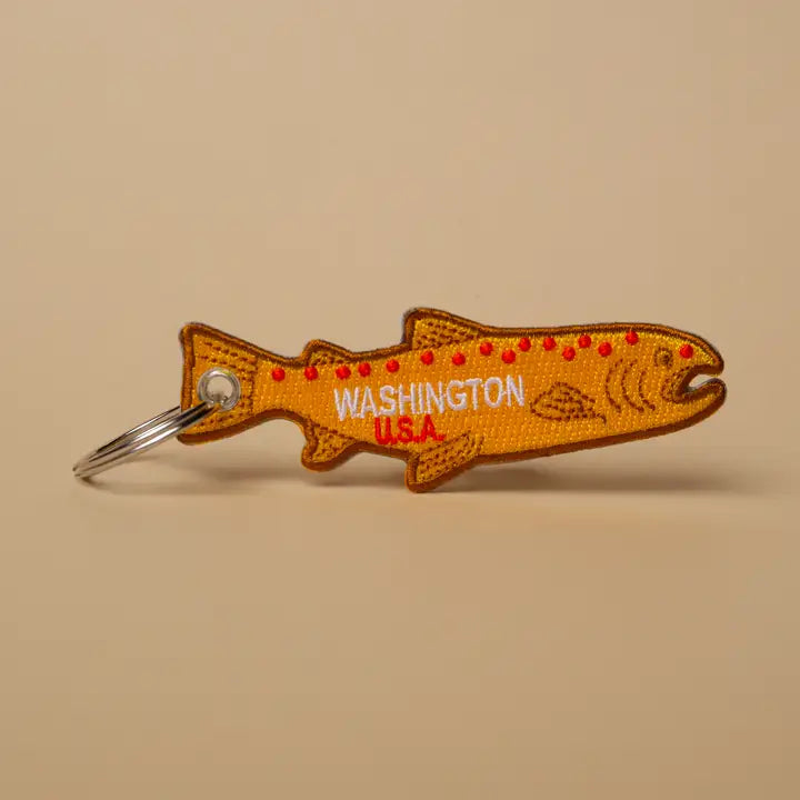 Fish-shaped keychain with 'Washington U.S.A.' text on a beige background