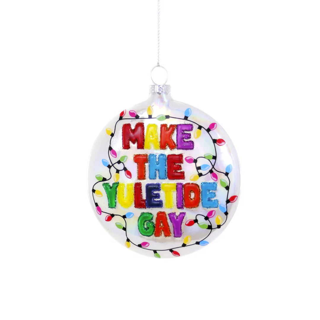 Decorative ornament with colorful text 'MAKE THE YULETIDE GAY' on a white background with colored twinkle light decoration
