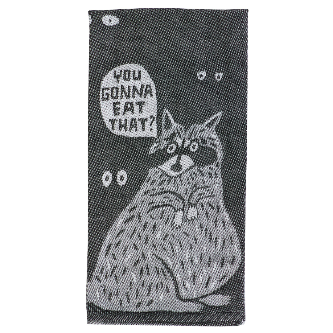 Folded tea towel. A grey raccoon asks "You gonna eat that?" with eyes in the background.