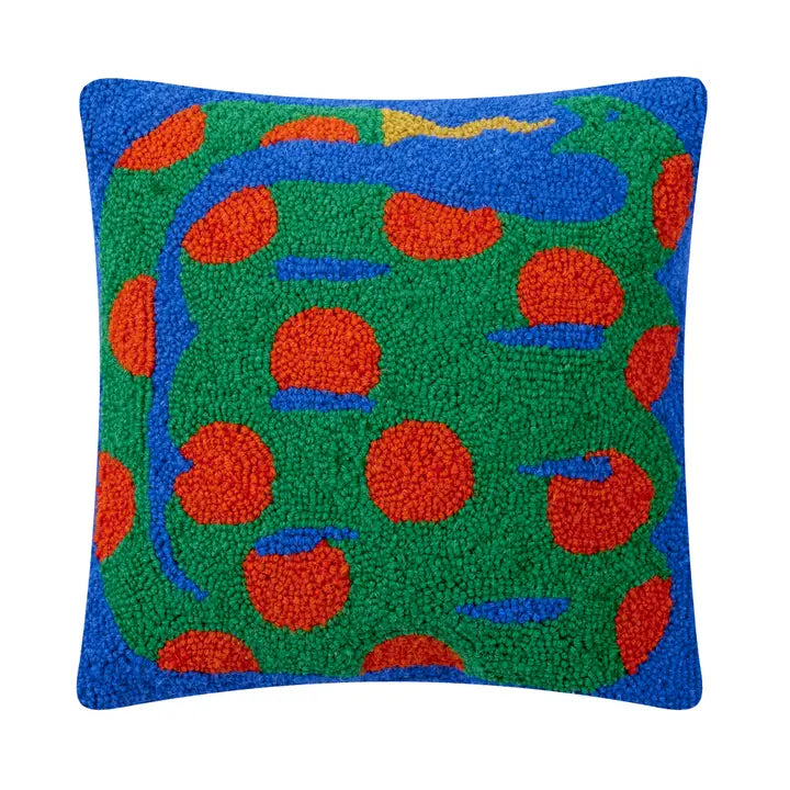 Pillow featuring a green and red snake fixing to eat its tail against a bright blue background