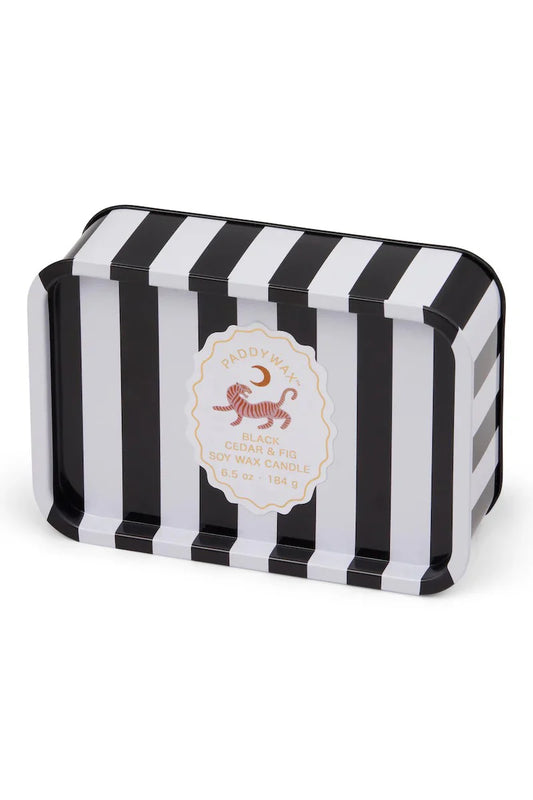 Black and white striped tin with a white label. Label has a tiger and moon on it and reads "Paddywax, Black Cedar & Fig Soy Wax Candle