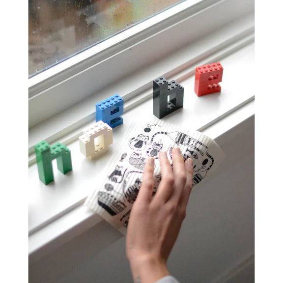 Sponge cloth being used to clean a window sill. 